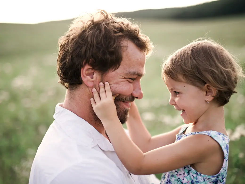 Junger Vater in Natur halten kleine Tochter in den Armen
