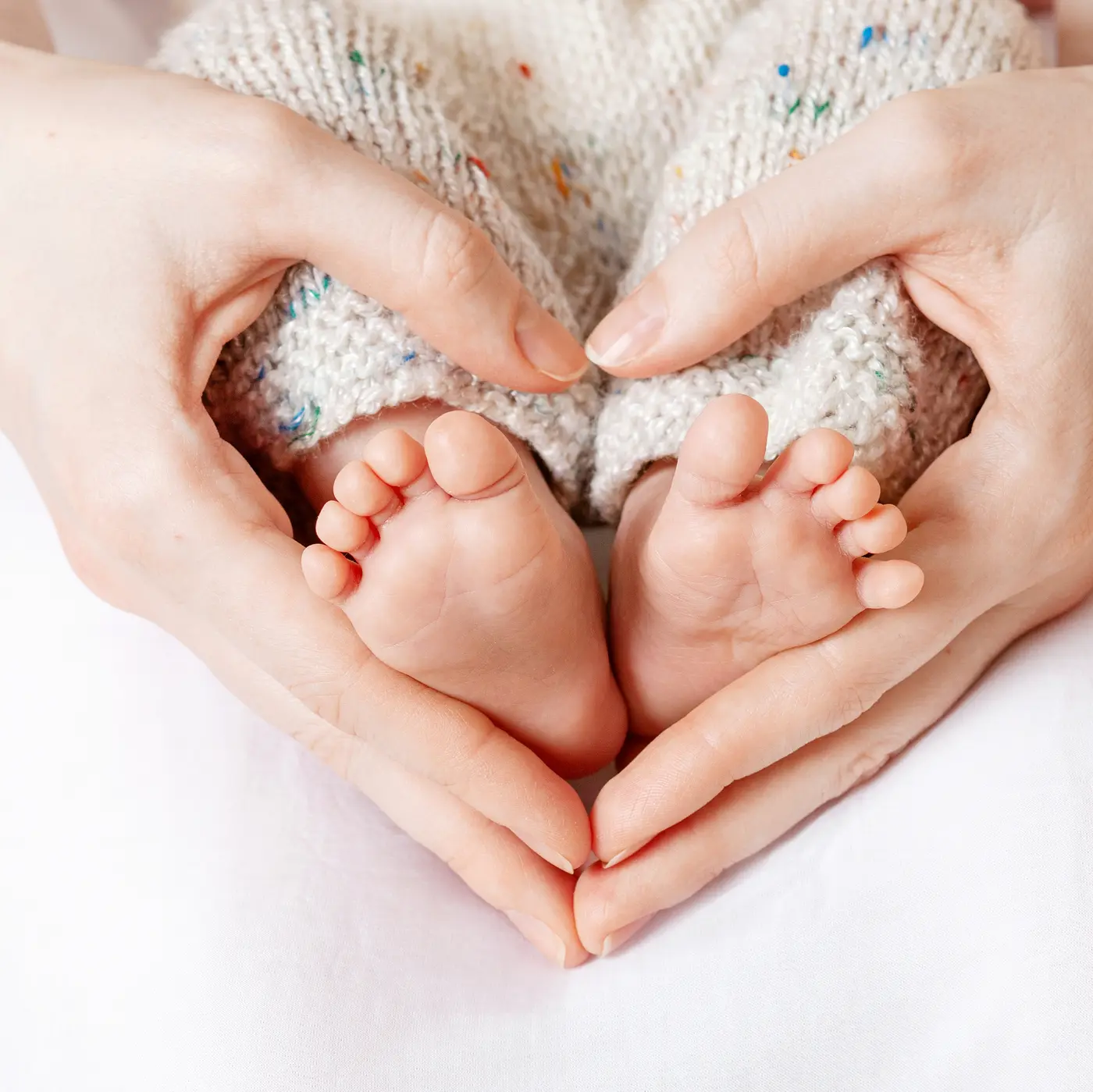 Babyfüße in Mutterhänden