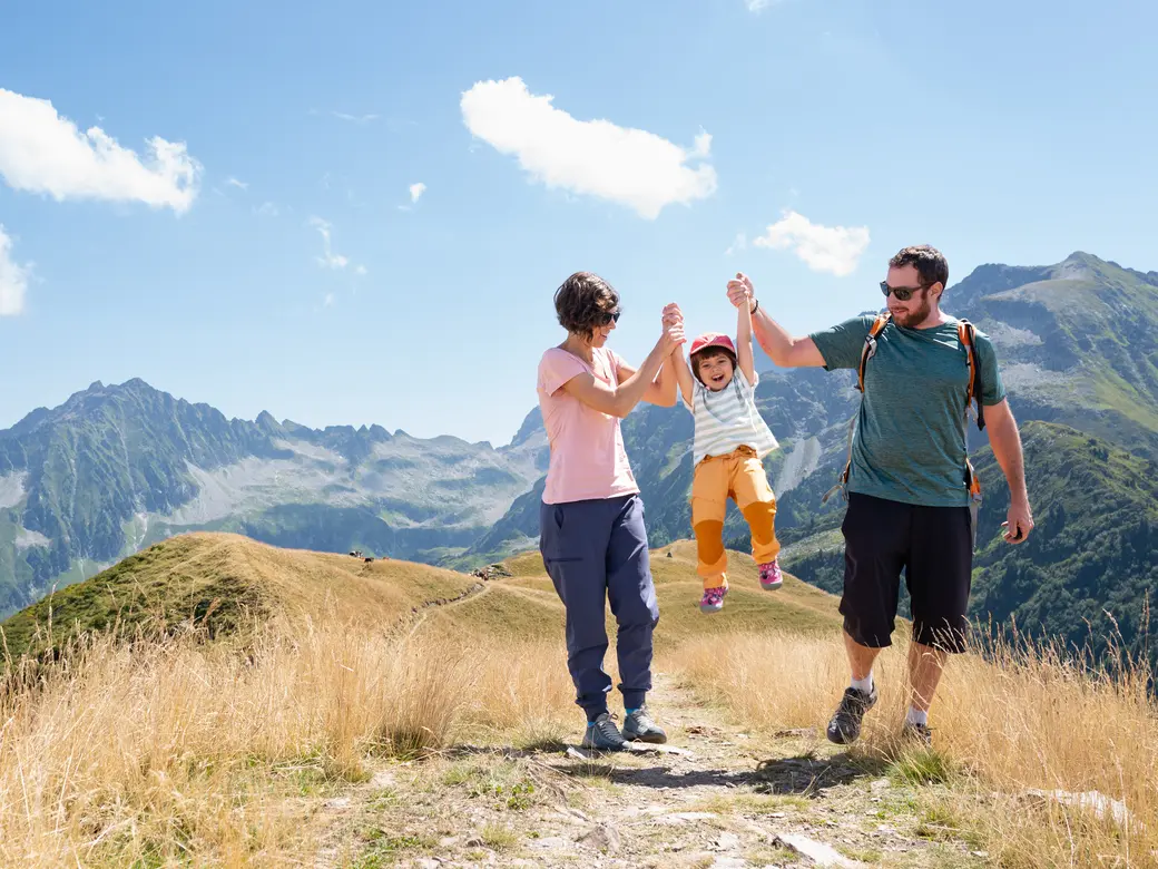 Mutter, Vater, Kind an den Händen halten während eines Wandertages