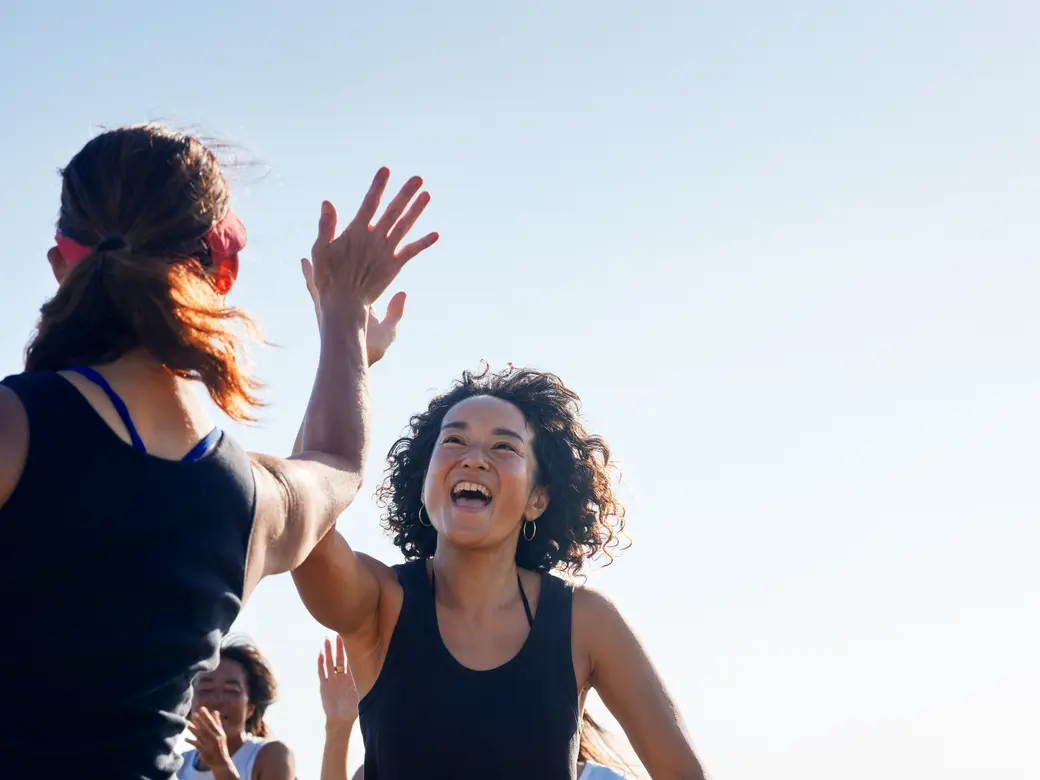 Zwei Frauen geben sich ein High-Five.