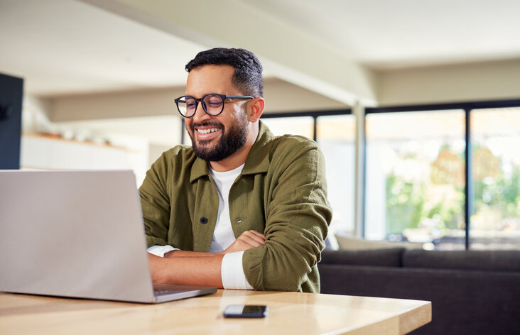 Mann, der zu Hause am Laptop arbeitet