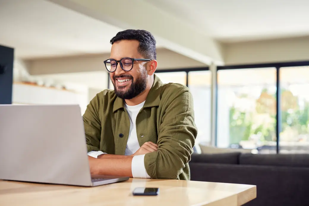 Mann, der zu Hause am Laptop arbeitet