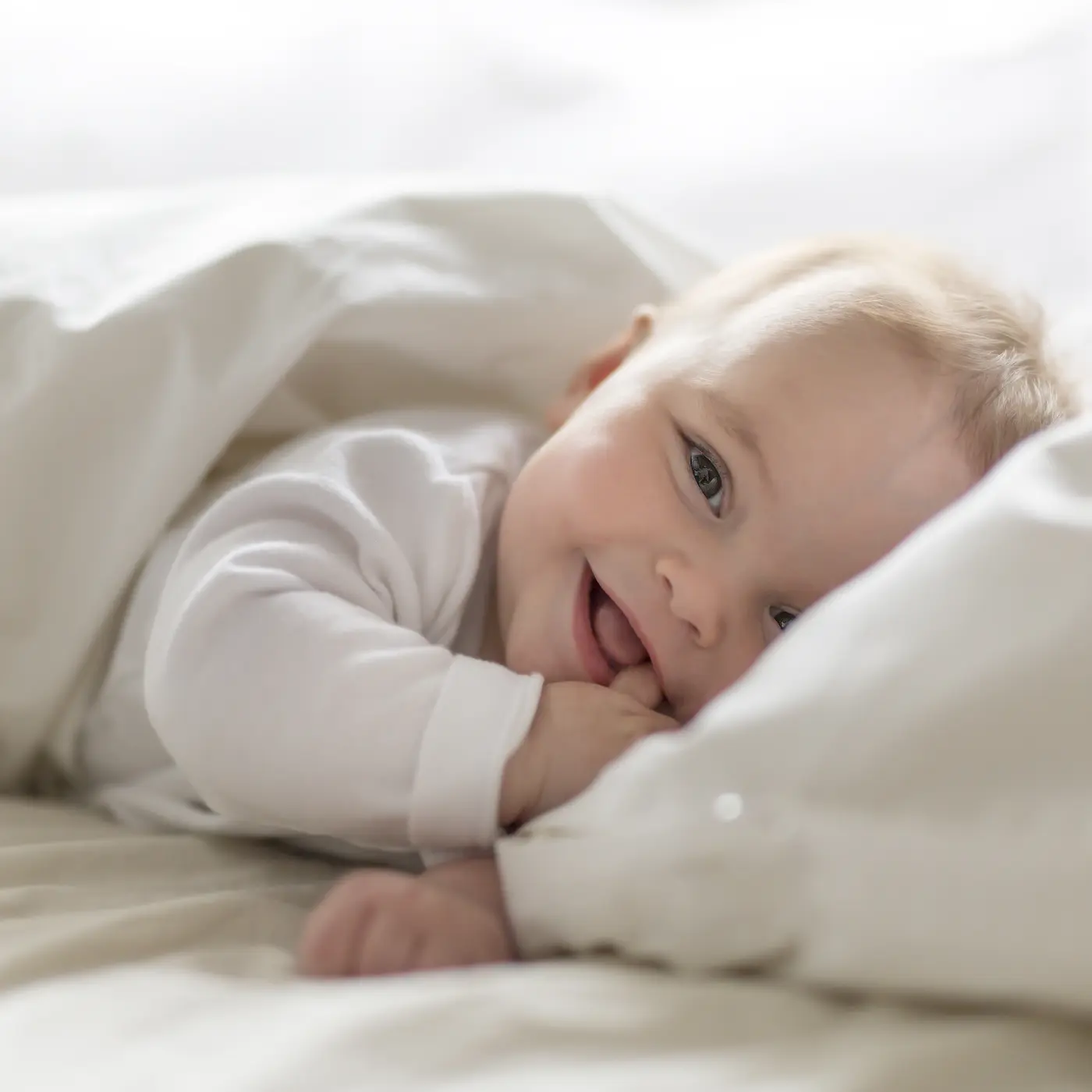 Baby Mädchen lächelnd im Bett